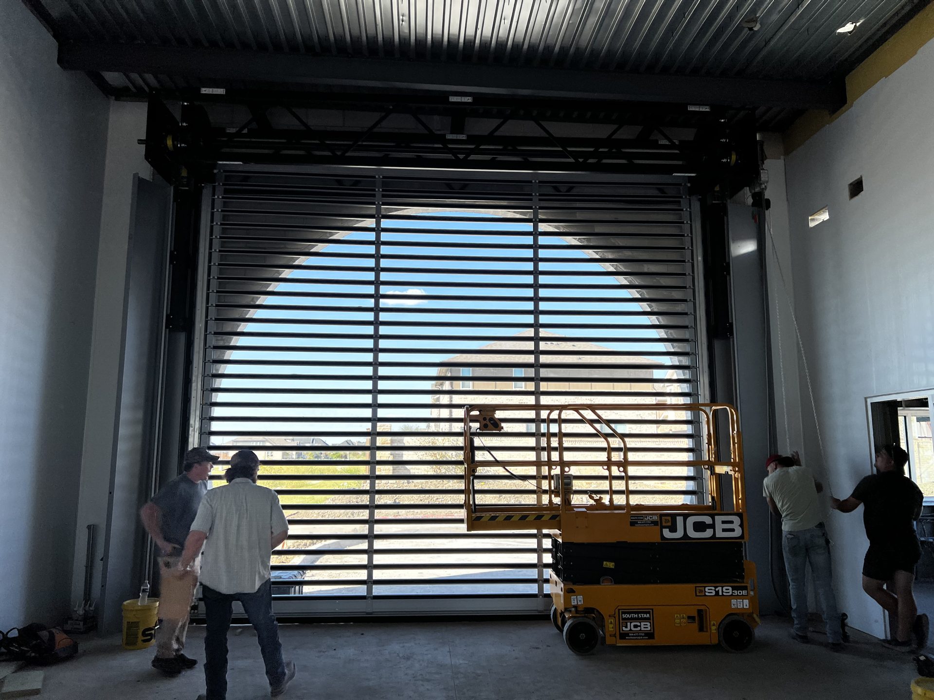 Installation of a commercial rolling grille door with a lift inside a large building