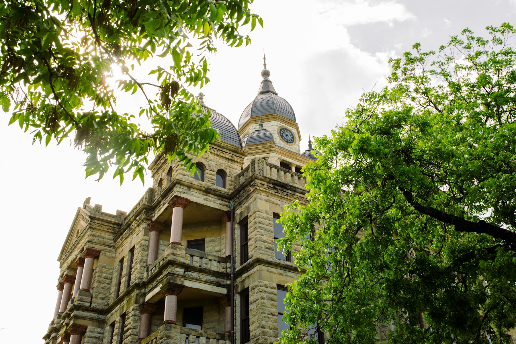Historic Denton courthouse framed by leafy trees