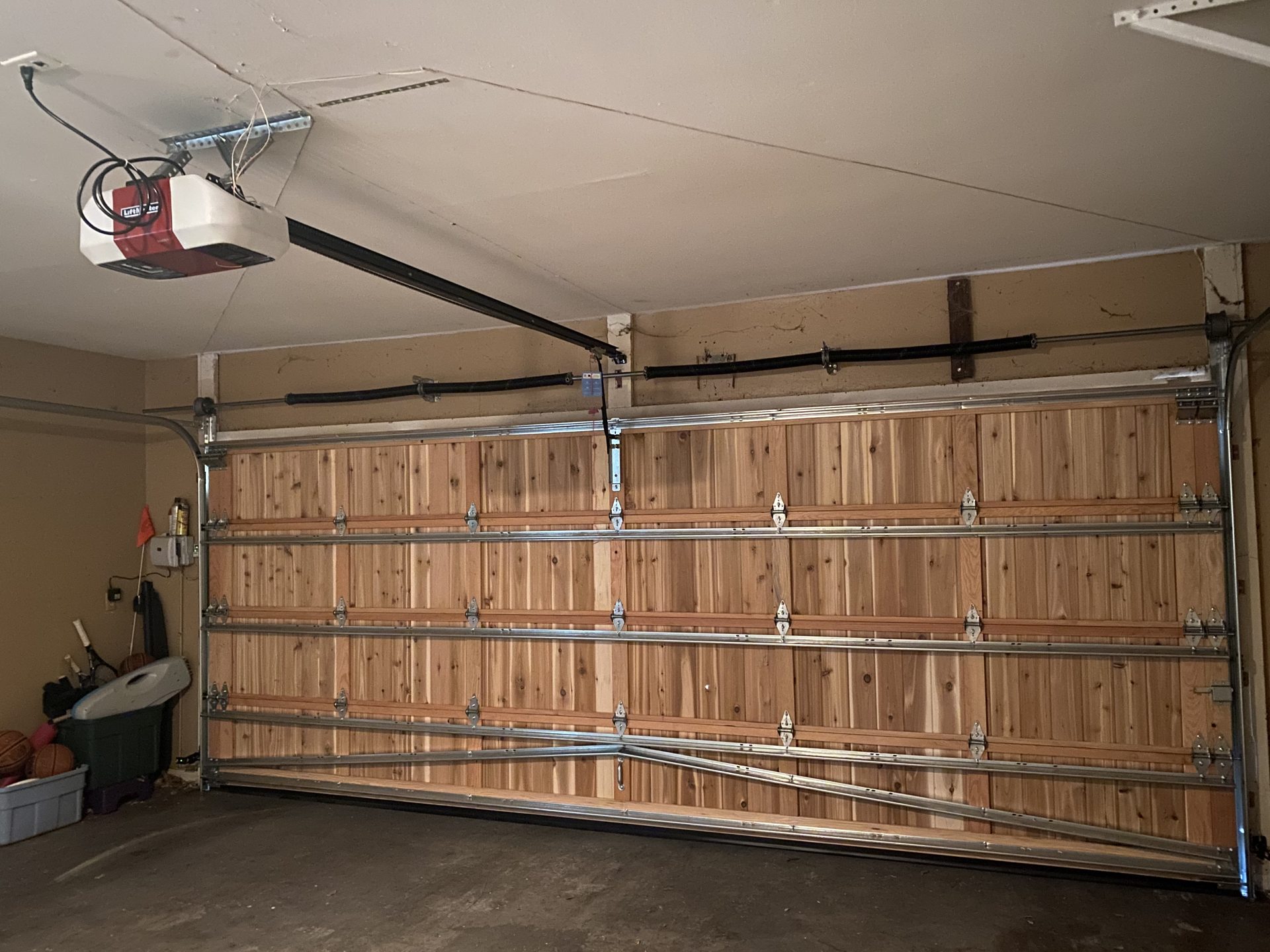 Wood garage door interior with torsion springs, tracks and reinforcing hardware
